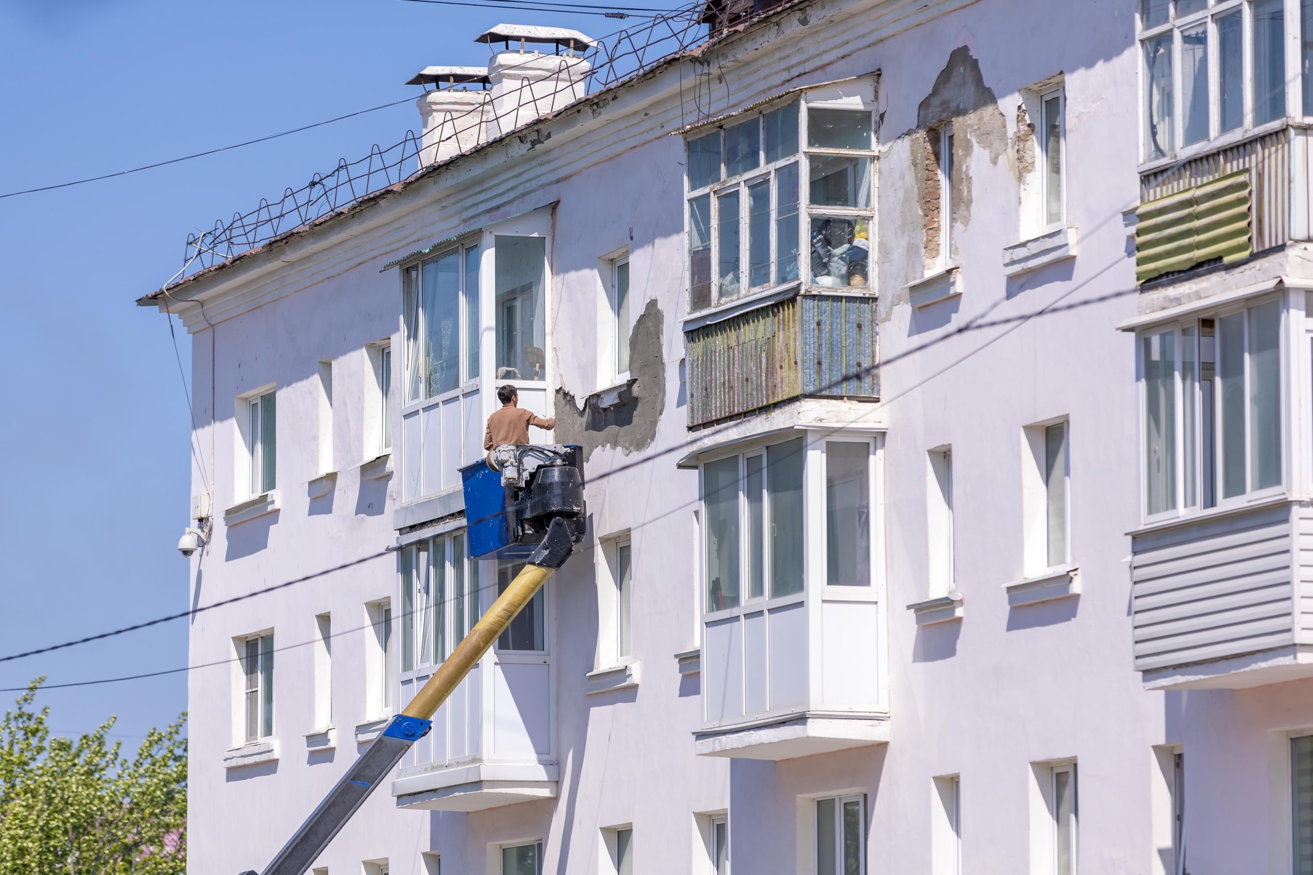 Travailleur rénove façade bâtiment nacelle élévatrice