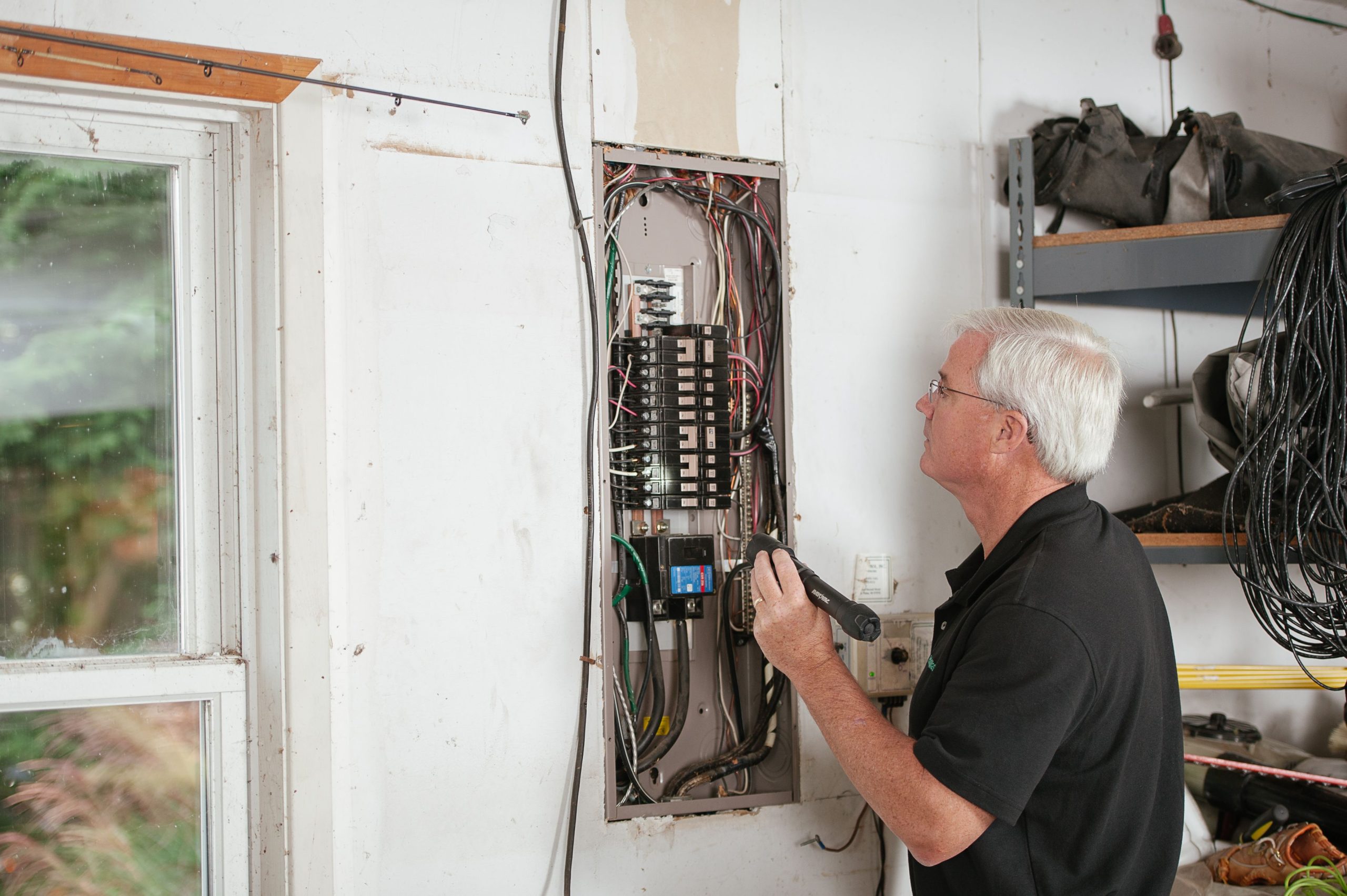 Électricien inspectant un boîtier électrique résidentiel