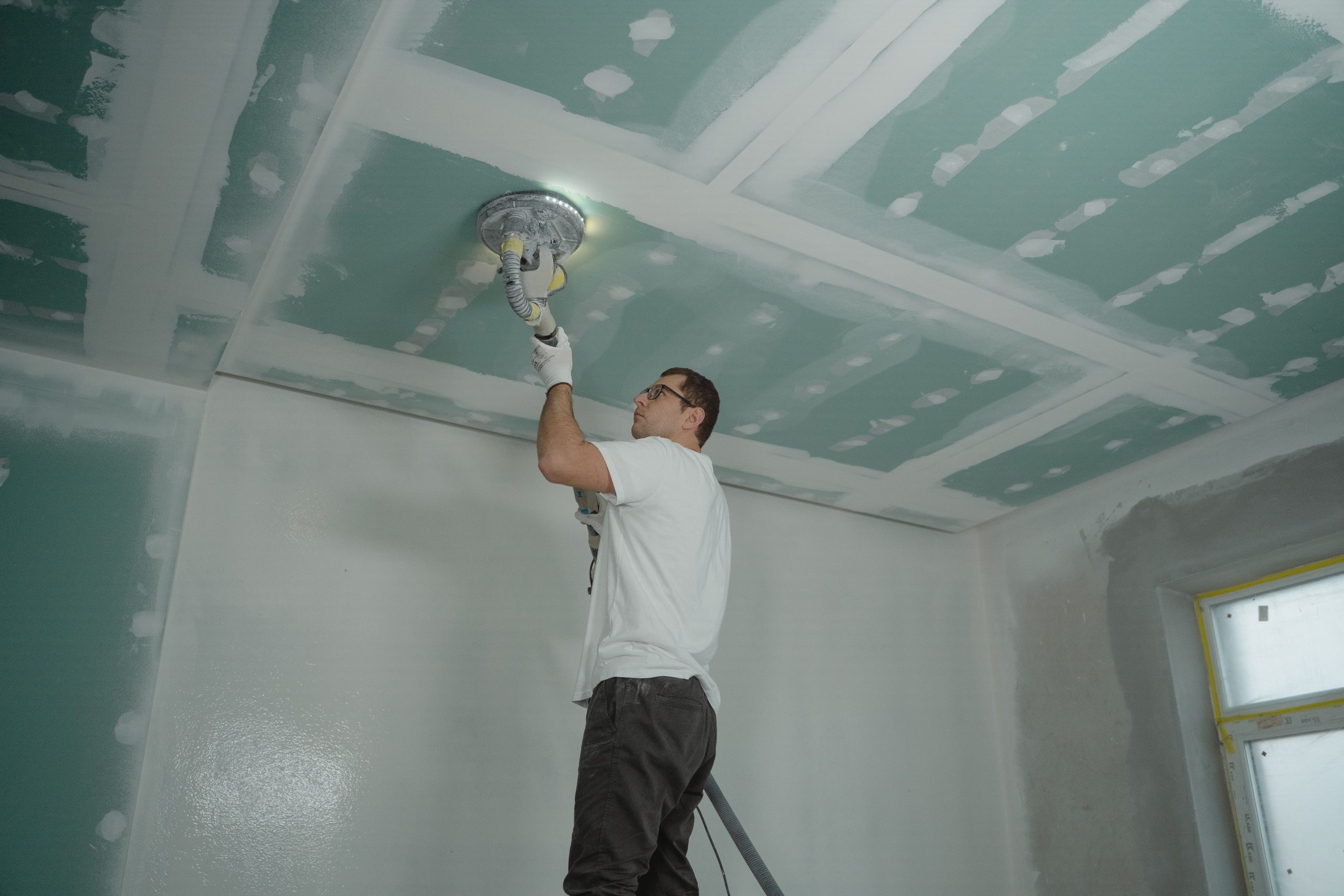 Ouvrier polissant le plafond intérieur expertise