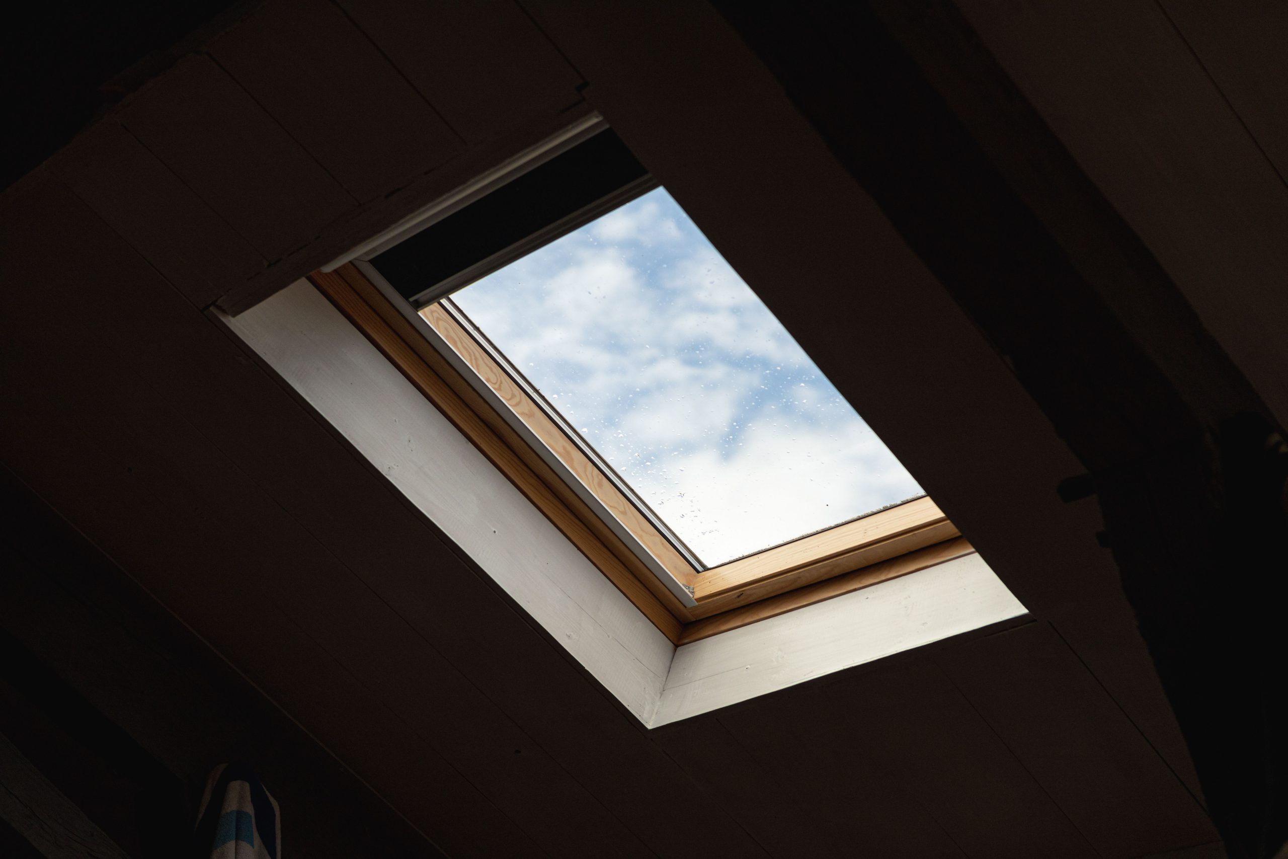 Velux dans pièce sombre avec ciel nuageux