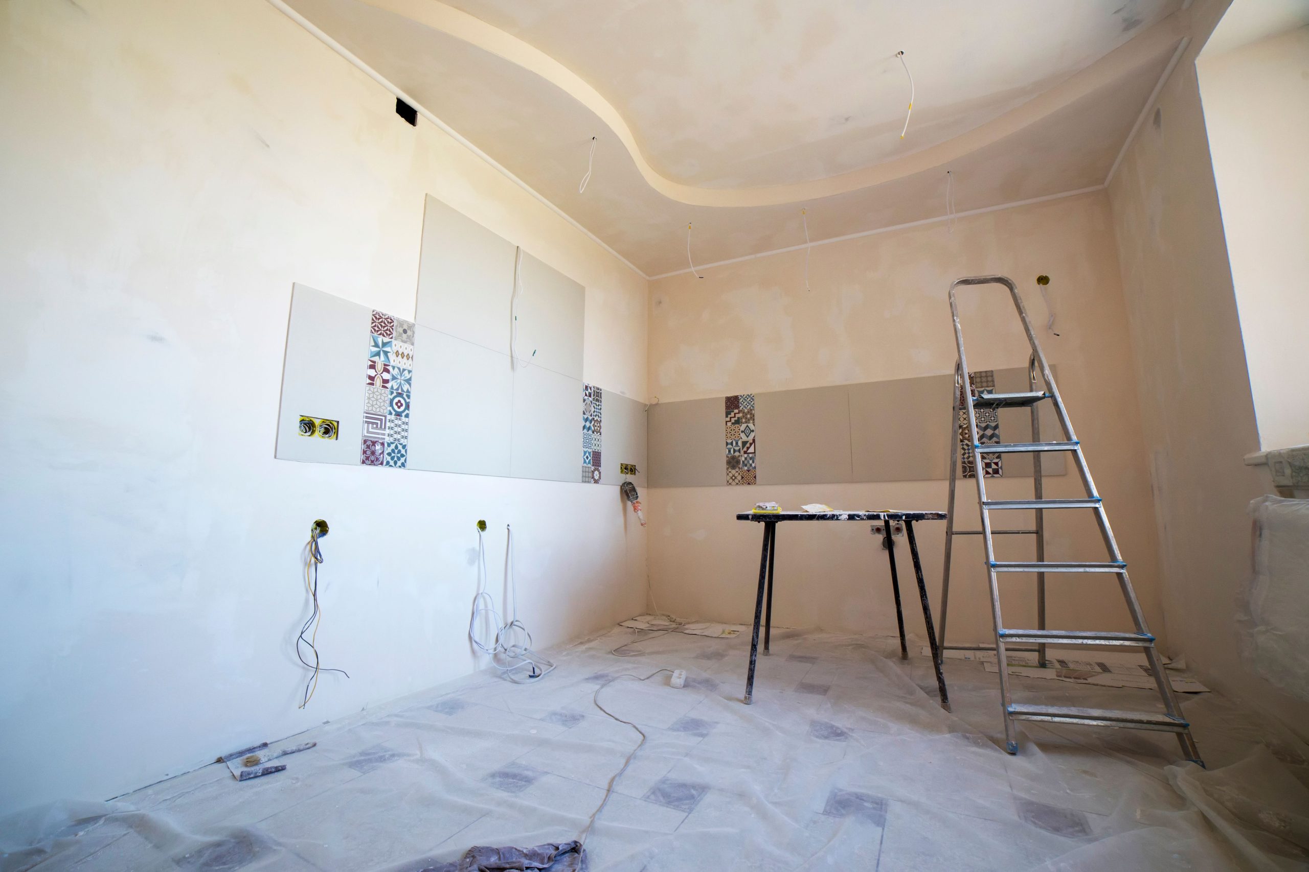 Pièce en rénovation avec peinture, carrelage et outils de travail.