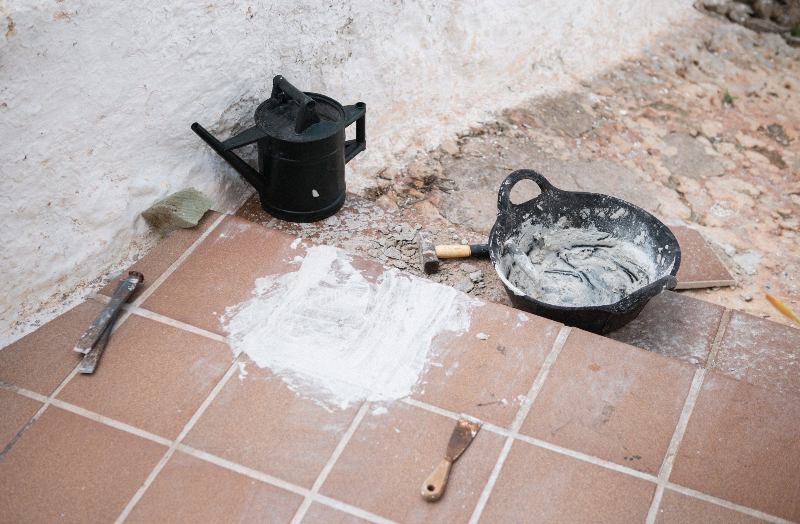 Matériaux de construction et outils sur carrelage en rénovation.